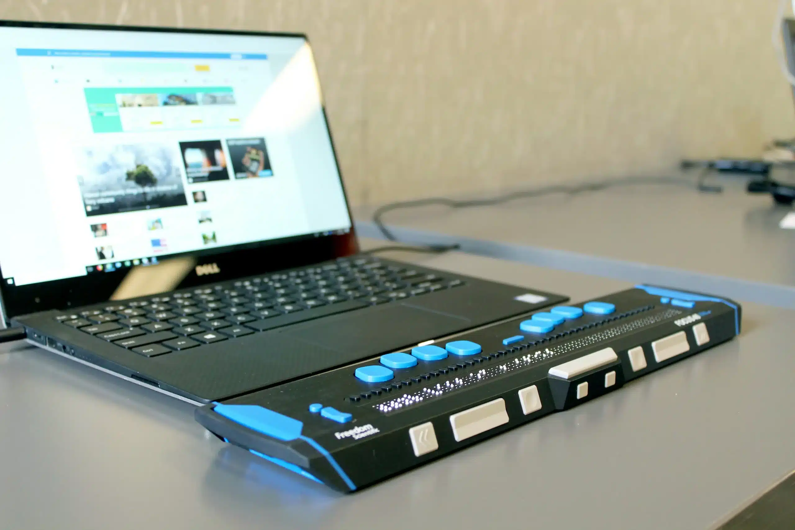 Des dispositifs physiques permettent à une personne d'utiliser son ordinateur, ici une sorte de clavier accolé au clavier d'ordinateur portable avec des boutons de différentes couleurs et formes. 
